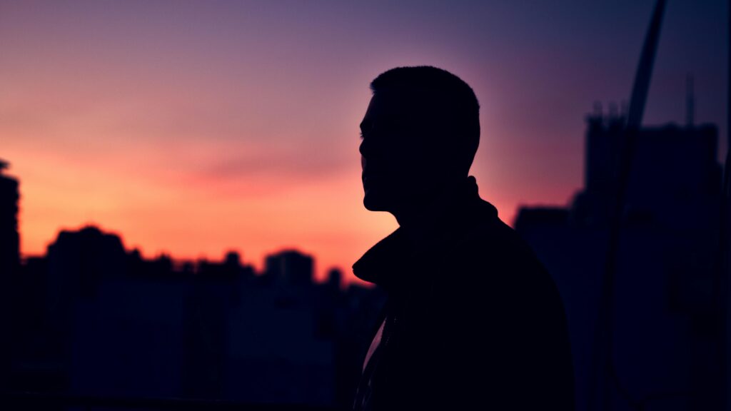 Silhouette of a man overlooking Buenos Aires skyline at twilight.